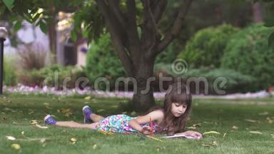 孩子在树下的草地上<strong>画画</strong>。 小女孩在后院用蜡笔<strong>画画</strong>